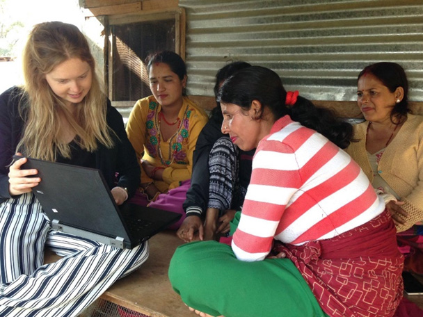 Volunteer giving computer lessons to women