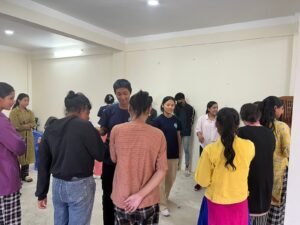 Volunteer teaching wheelchair mobility skills to a disabled participant in Nepal